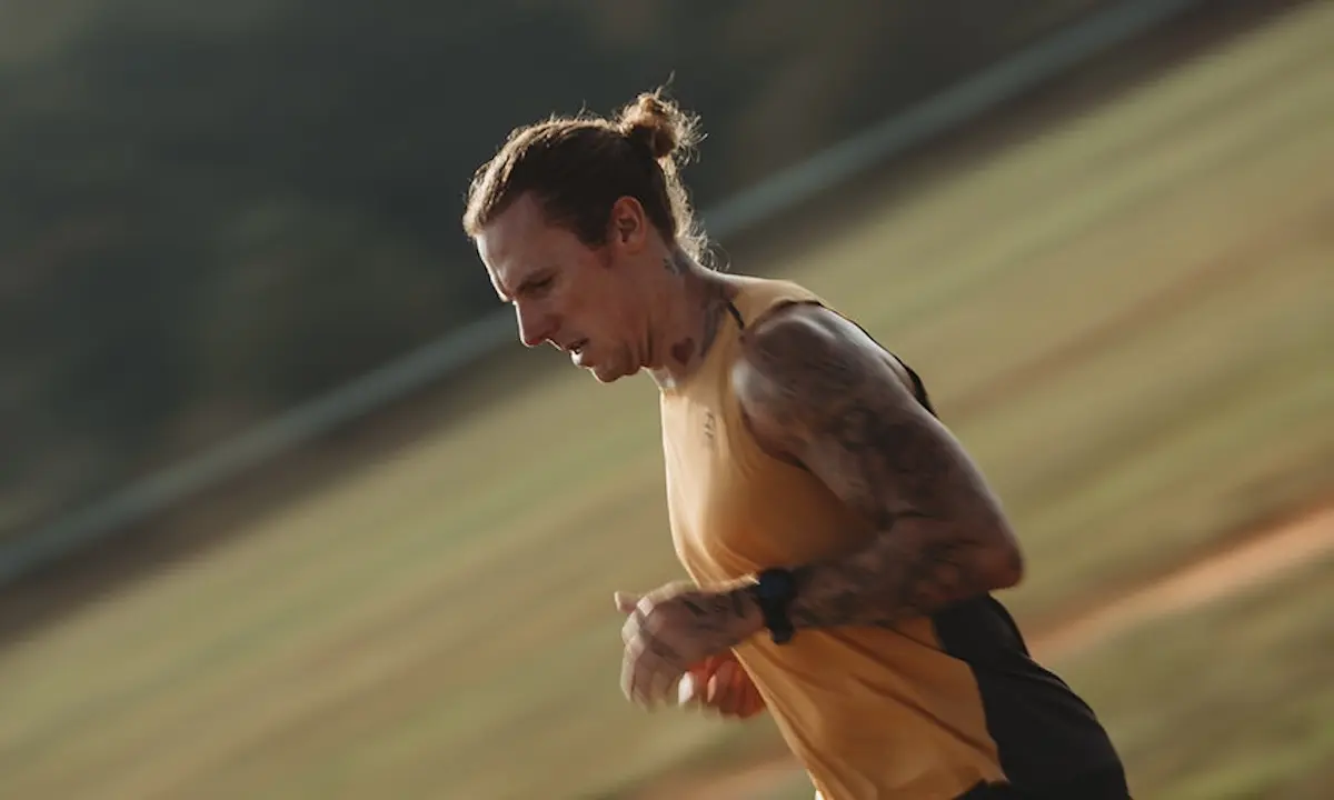 Man running outdoors in yellow tank top