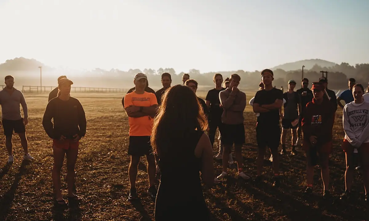 woman addressing an outdoor group of people at sunrise