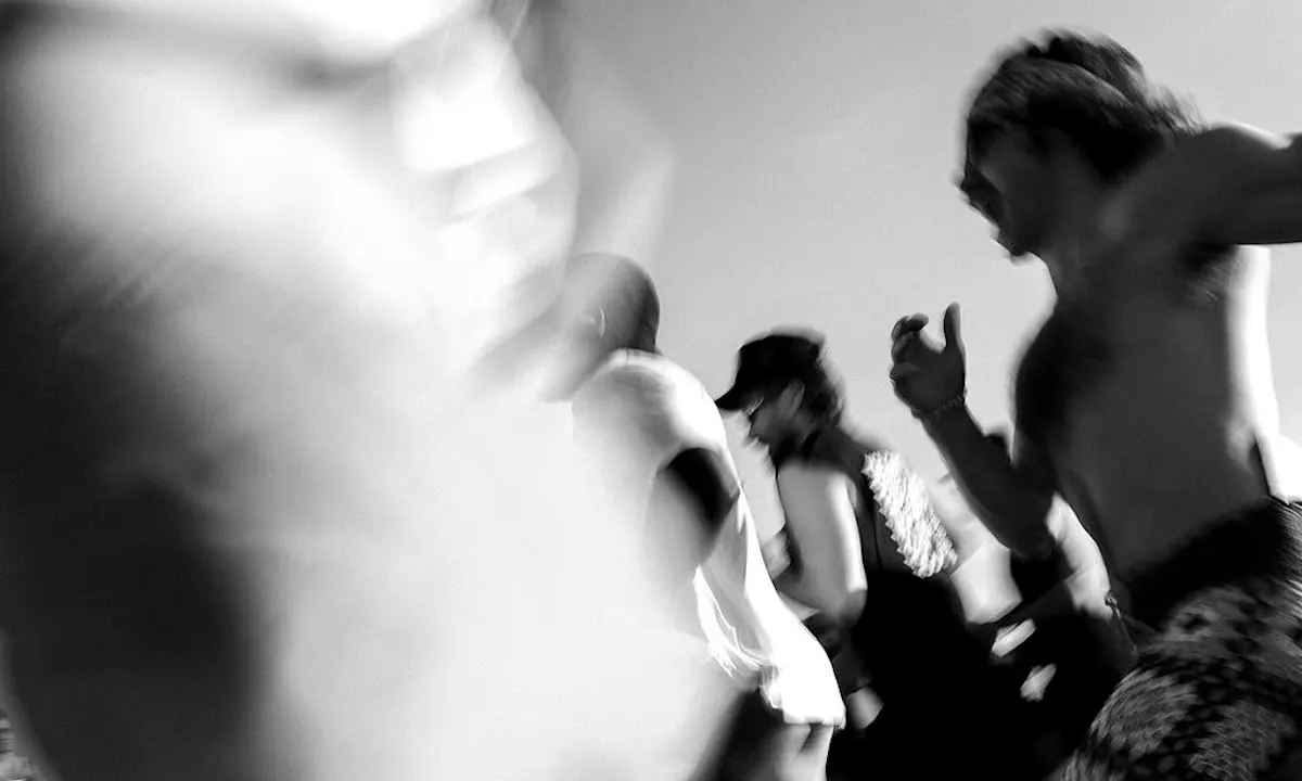 Blurry black-and-white crowd in motion with shirtless participants